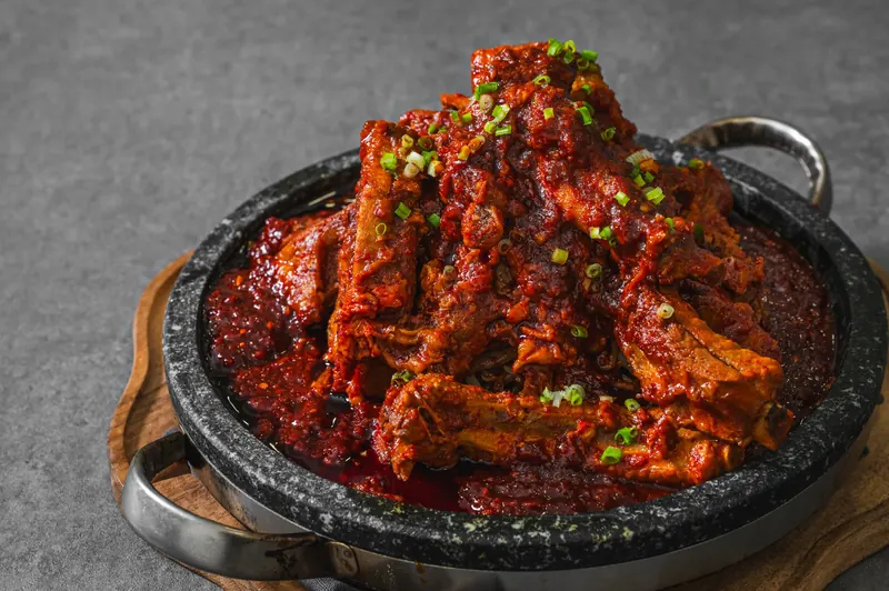 윤기 나는 붉은 양념이 밴 돌판 양념 등갈비구이를 가까이에서 본 모습