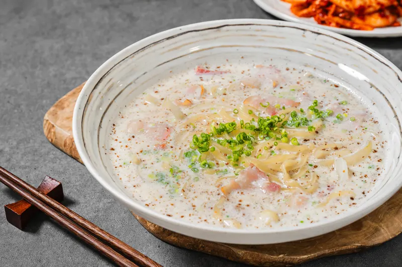 잘게 썬 파가 올라간 부드러운 크림빛 들깨크림칼국수